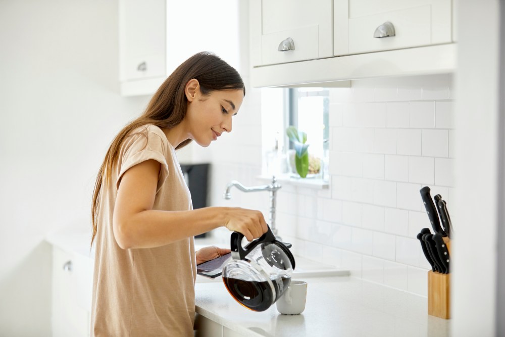 Una mujer sirviéndose una taza de café
