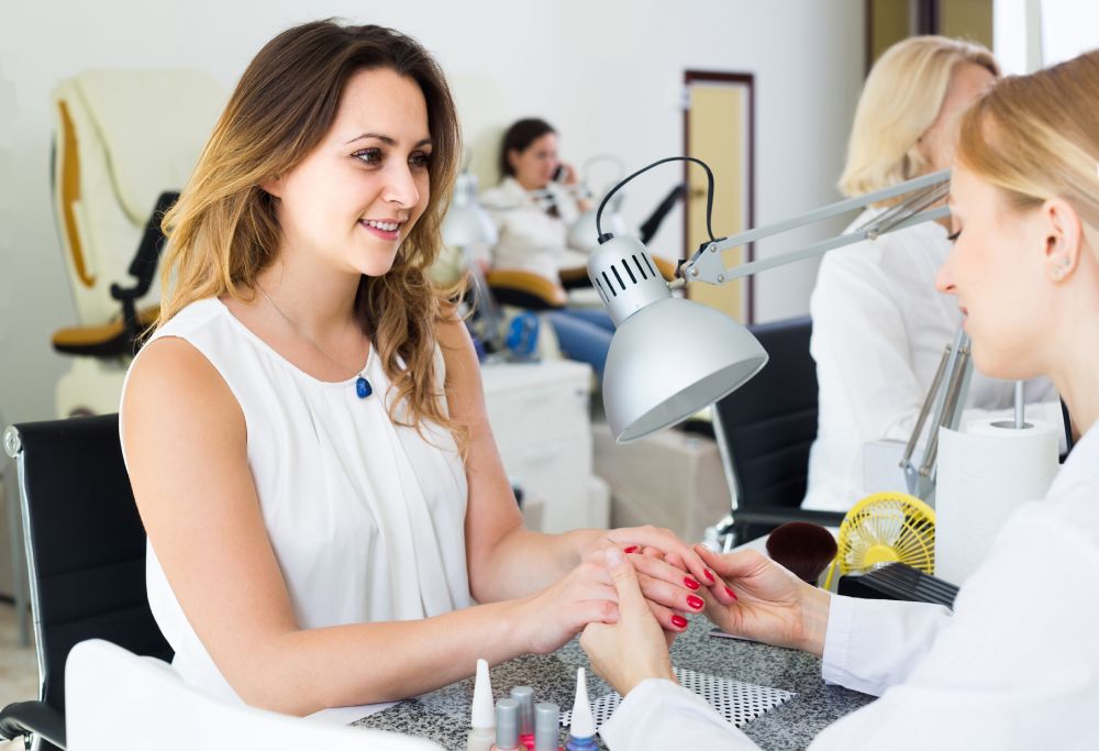Una mujer haciéndose la manicura en un salón de belleza
