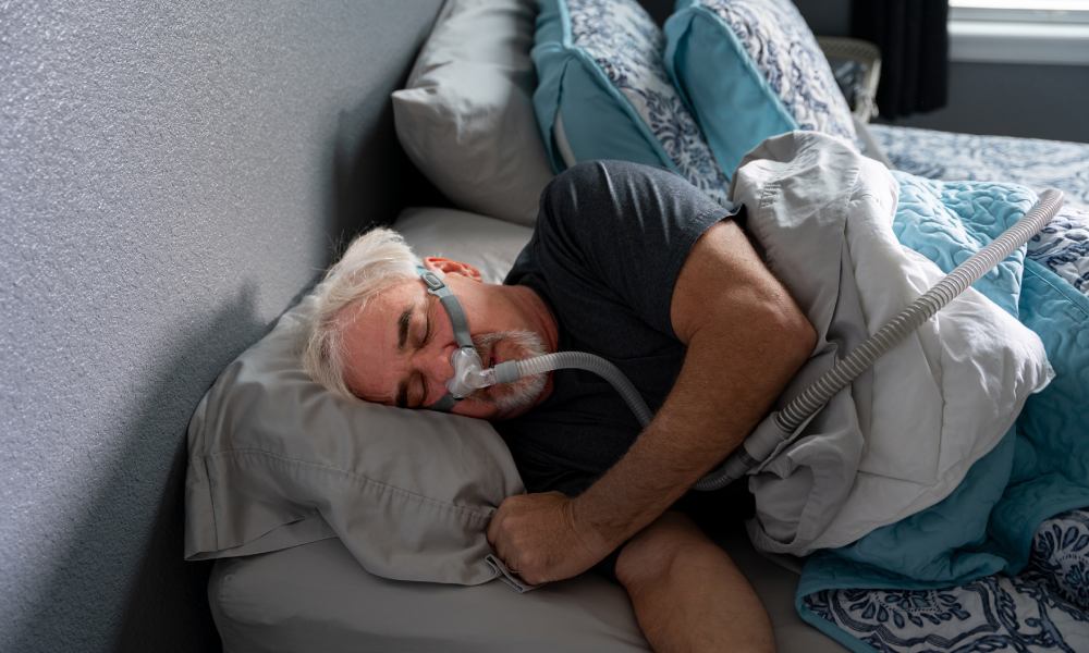 Un hombre durmiendo con la mascarilla de la máquina CPAP puesta
