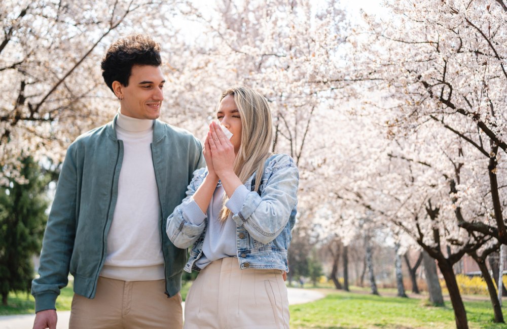 Mujer con alergia primaveral, paseando con su pareja por el parque