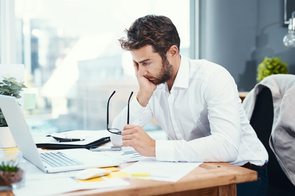 Un hombre con gesto cansado en el trabajo