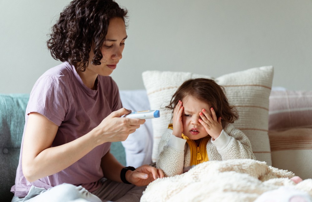 Una madre controlando la fiebre de su hija