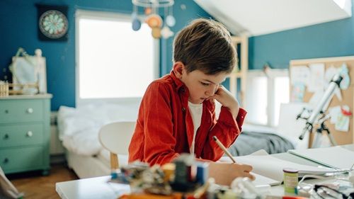 Un niño estudiando en su habitación
