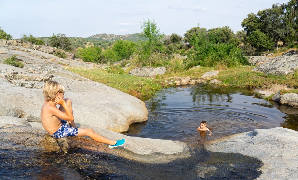 Dos niños jugando en una piscina natural