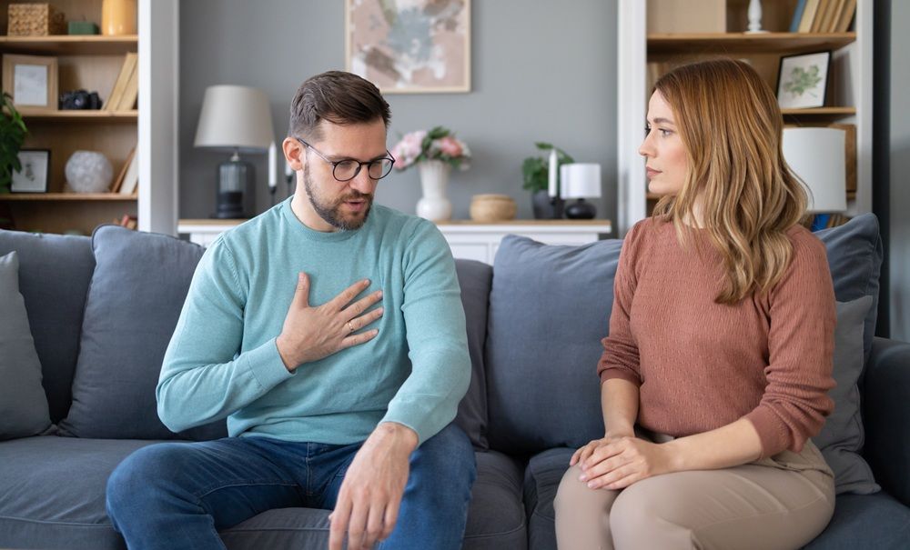 Una pareja mantiene una conversación en el salón de casa
