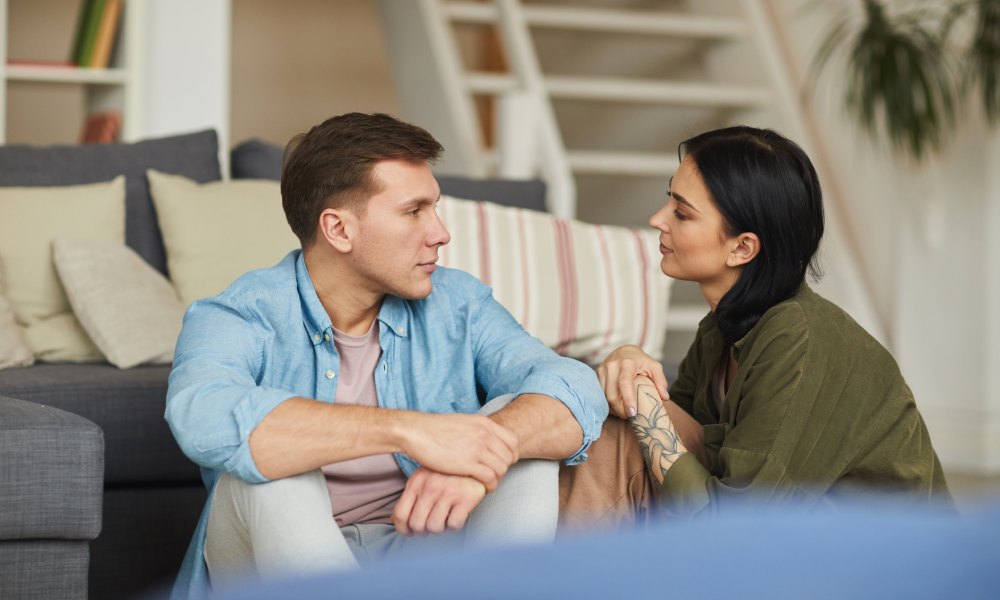 Una pareja mantienen una conversación en el salón de casa