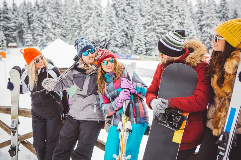 Un grupo de amigos preparados para practicar esquí o snowboard en la nieve