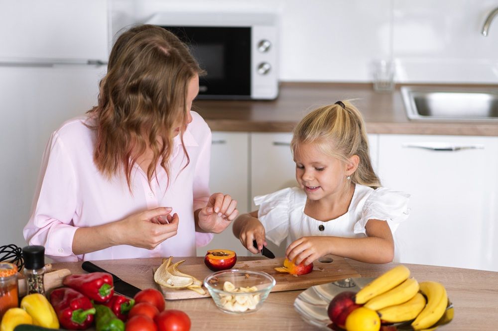 Madre e hija en la cocina, preparando el desayuno
