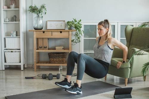 Una deportista practica ejercicio en el salón de su casa
